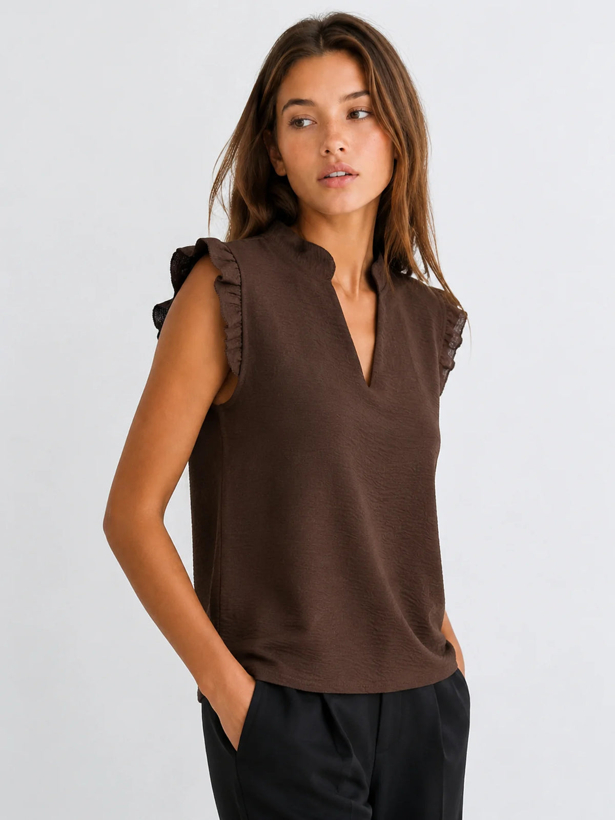 Mujer con blusa fluida marrón y pantalón negro, look casual