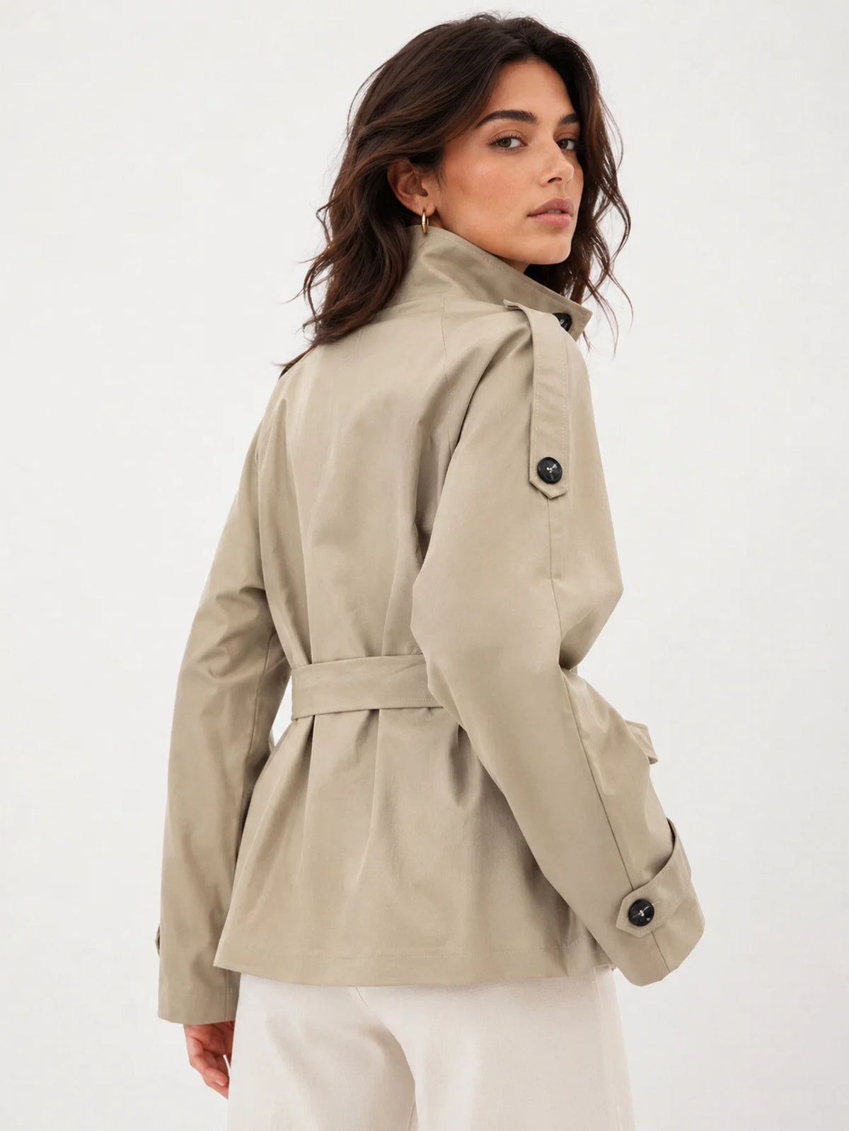 Vista trasera de chaqueta corta de estilo gabardina con cinturón y detalle en puños
