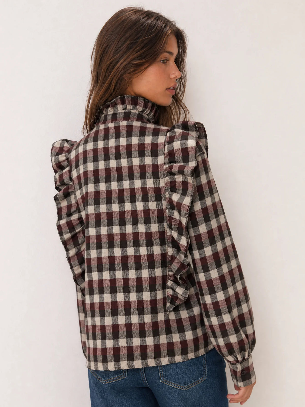 Vista trasera de blusa de manga larga con estampado de cuadros.