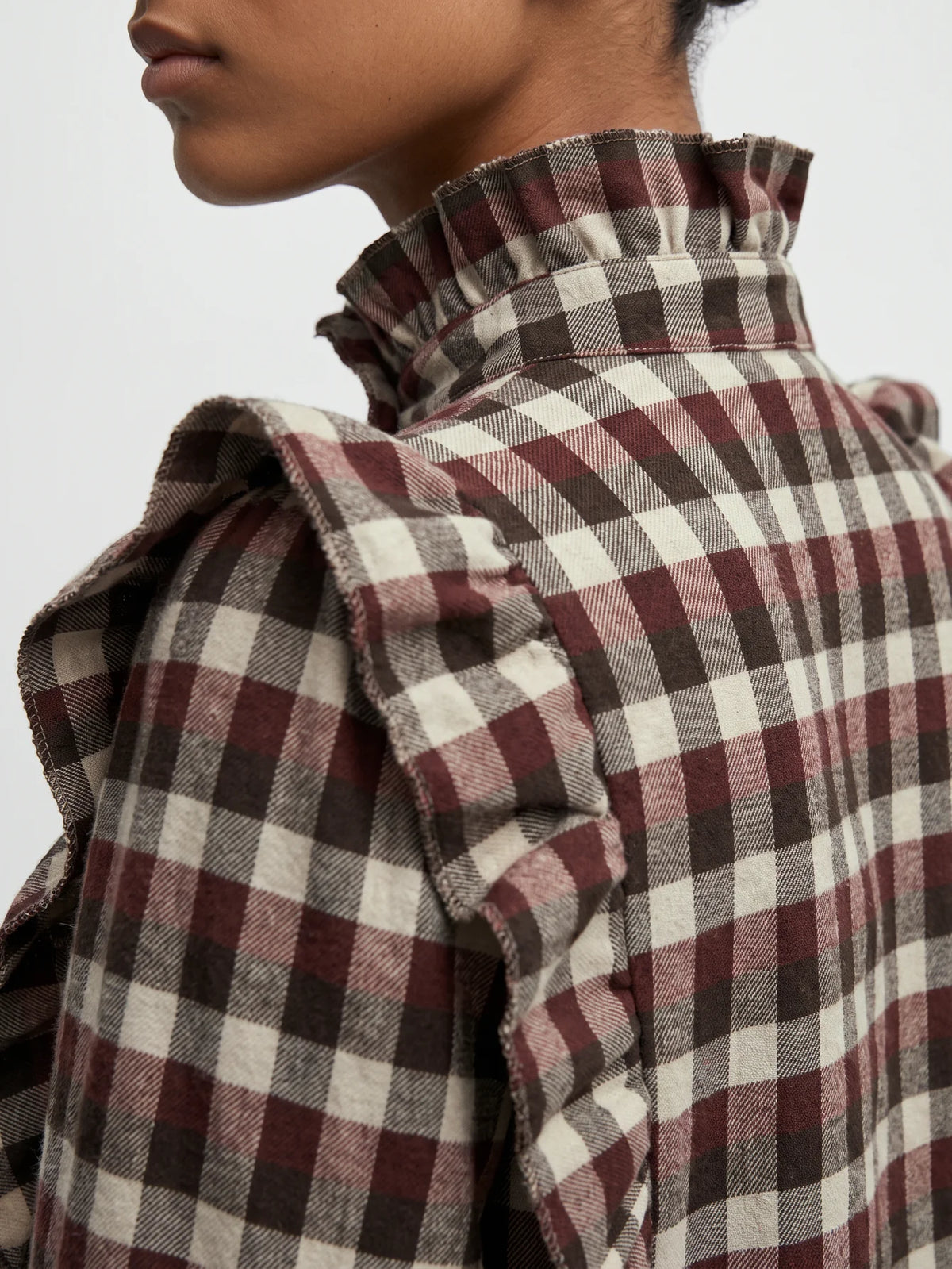 Detalle del cuello subido y tejido de mezcla de algodón de blusa de mujer.