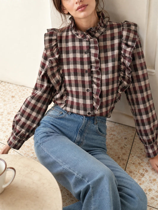 Blusa de cuadros burdeos con volantes y cuello subido para mujer combinada con vaqueros.