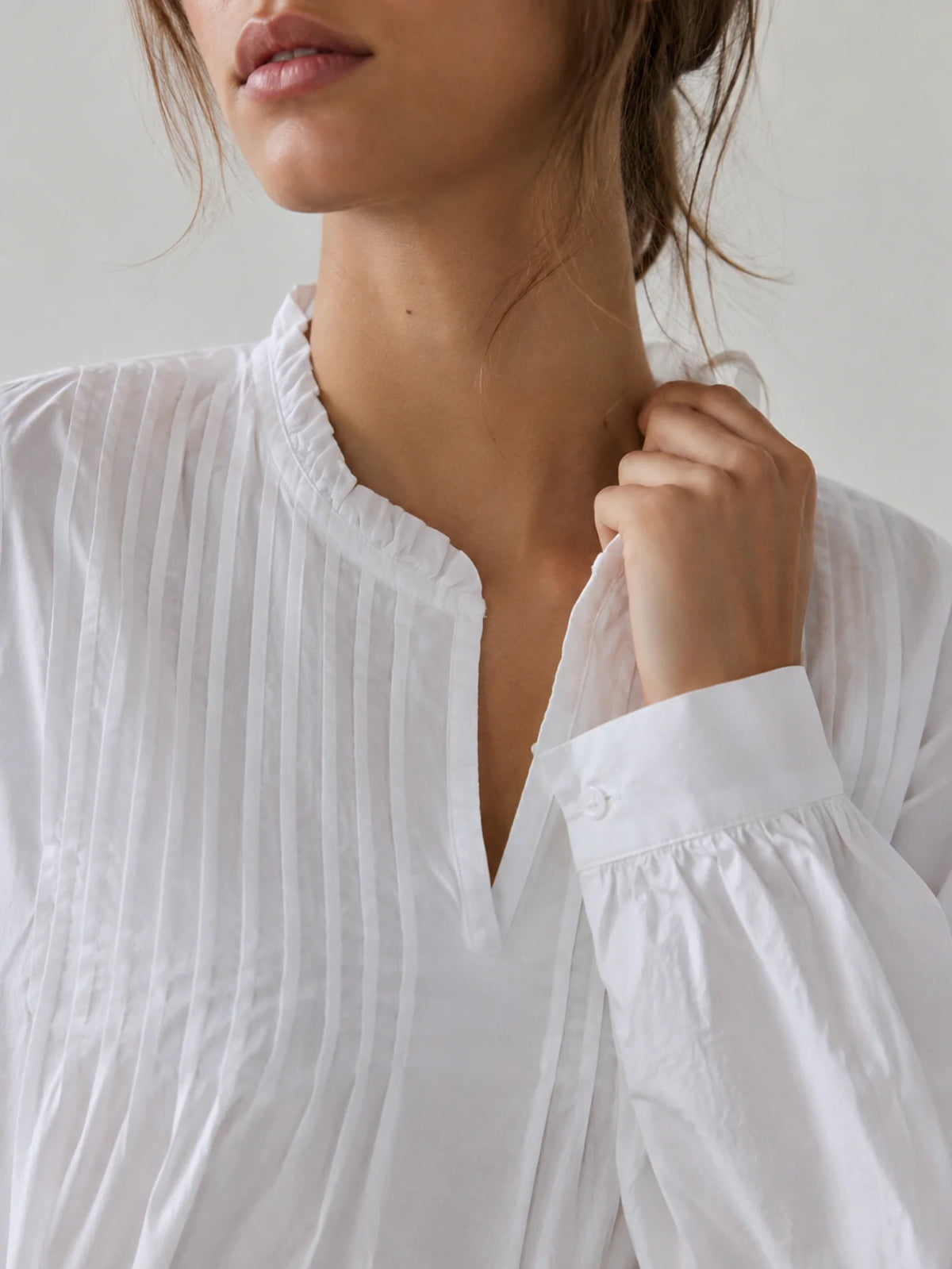 Detalle de los acabados y manga larga de la blusa de algodón para mujer