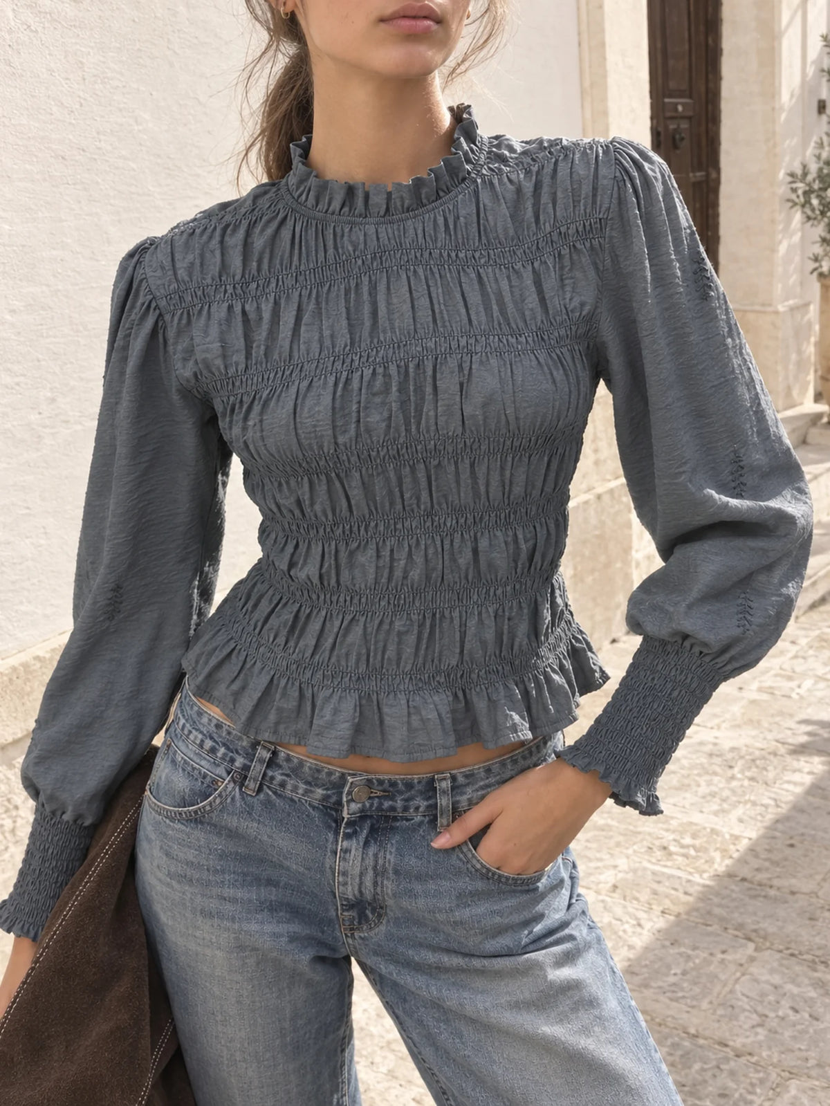 Blusa de manga larga gris con nido de abeja y cuello subido combinada con vaqueros