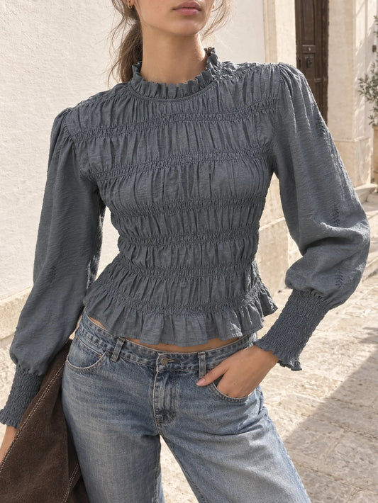 Blusa de manga larga gris con nido de abeja y cuello subido combinada con vaqueros