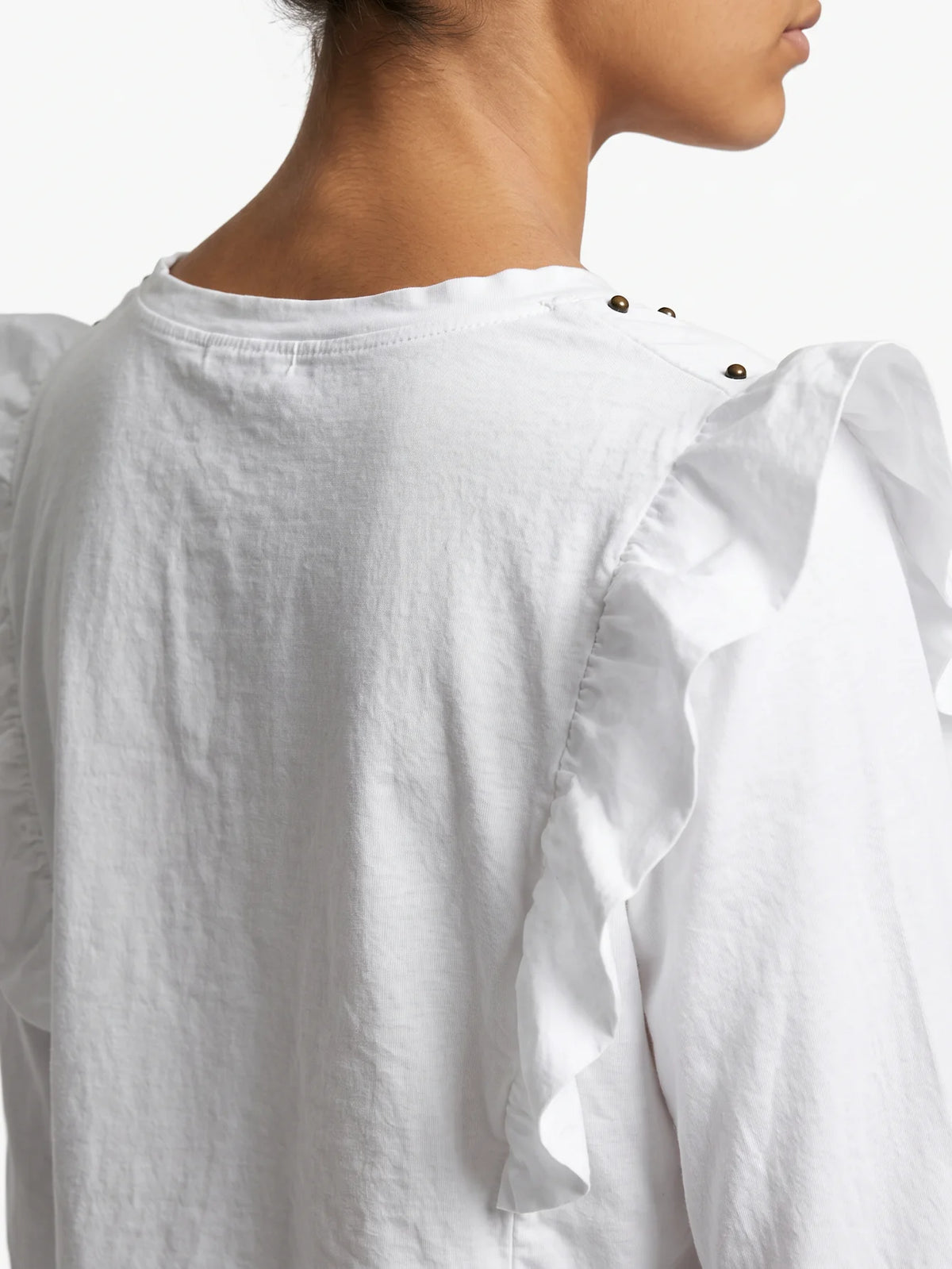 Camiseta blanca de manga larga con volantes en los hombros vista de espaldas