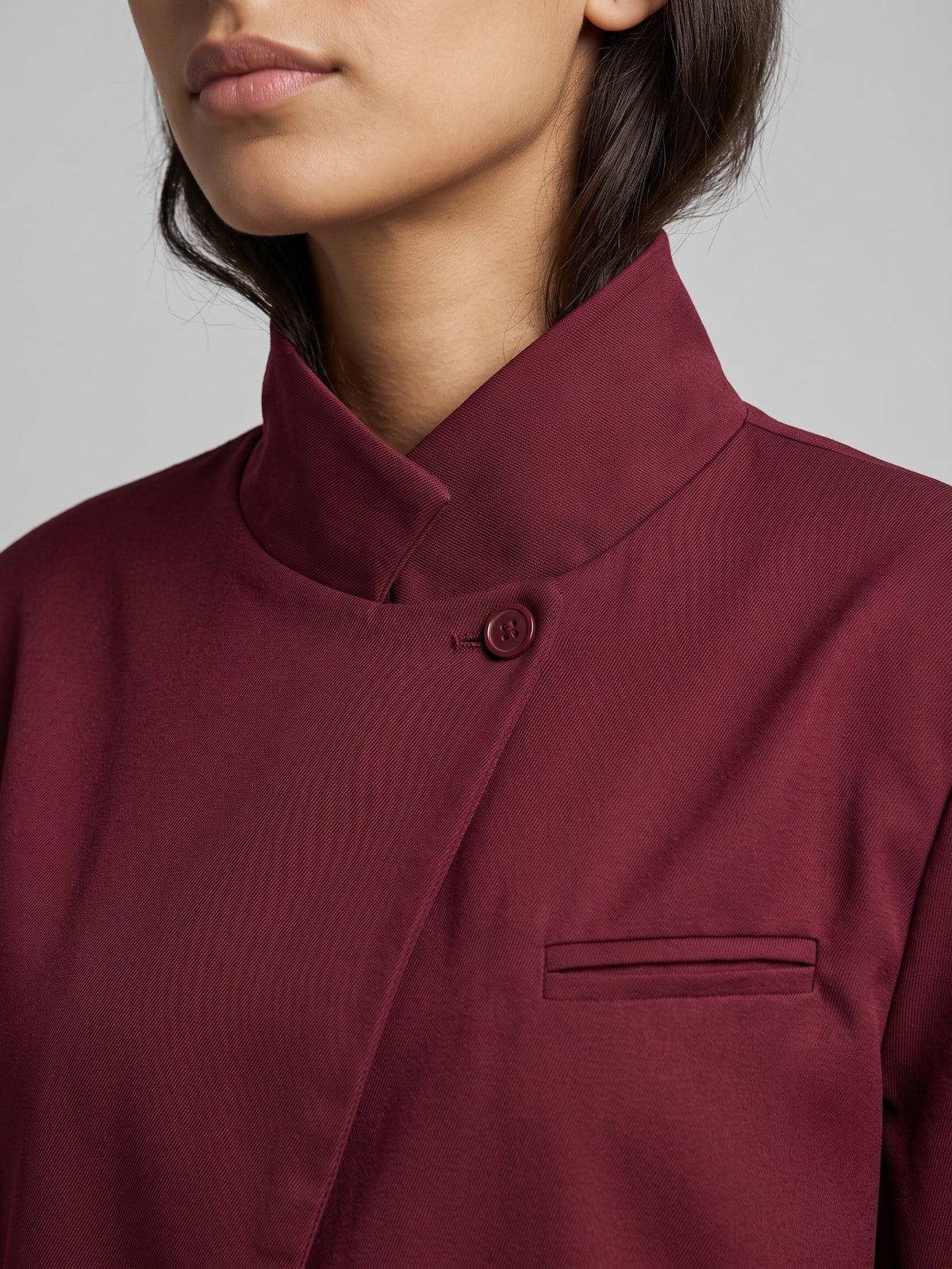 Detalle de cuello alto y solapa cruzada de blazer burdeos de vestir para mujer