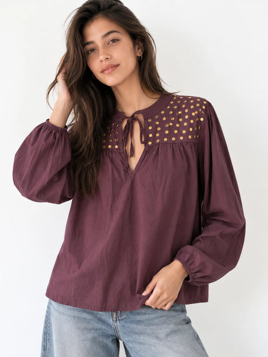 Detalle de manga larga y tachuelas doradas en blusa estilo boho