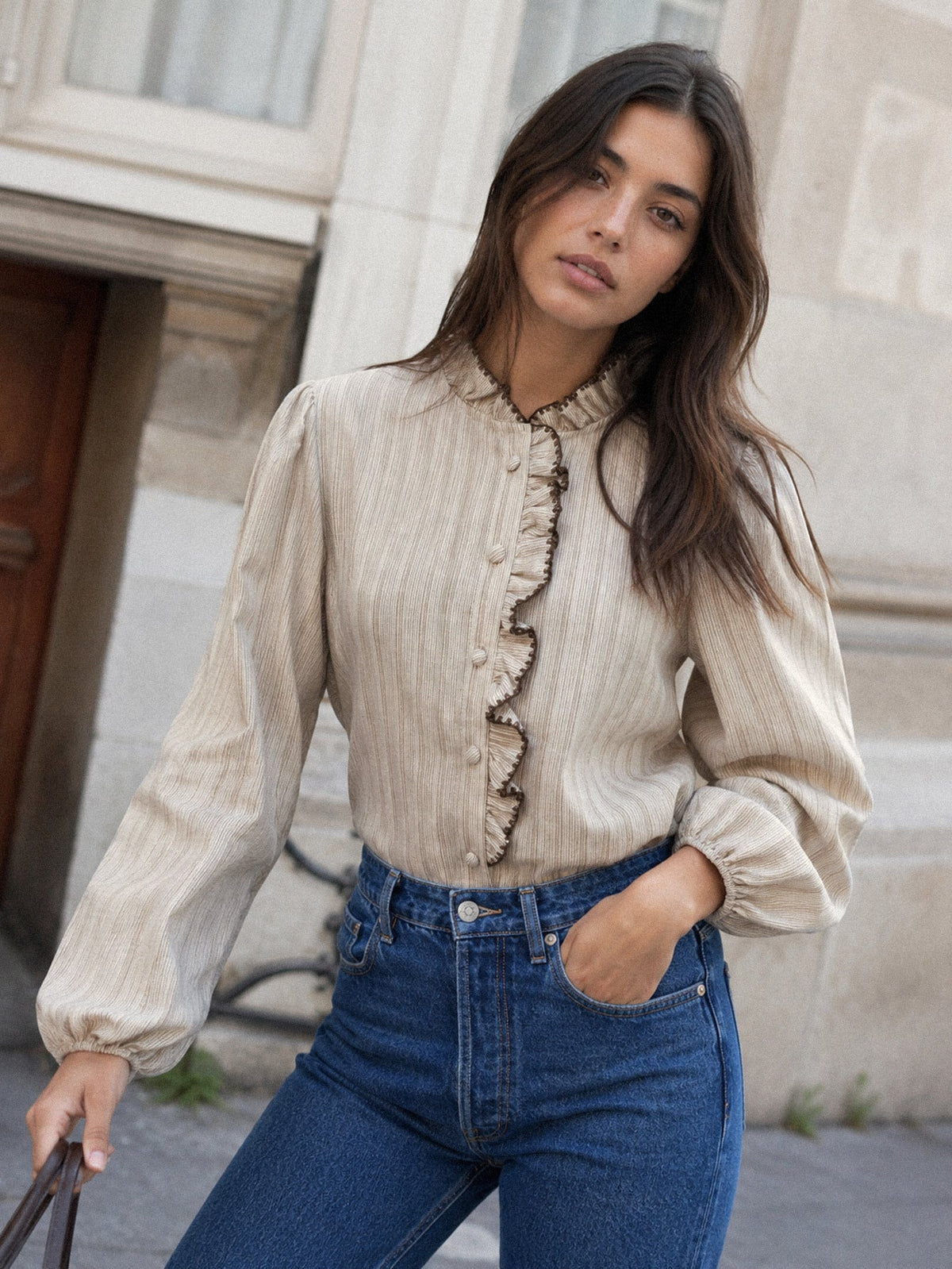 Mujer luciendo camisa de rayas con textura, cuello subido y volantes